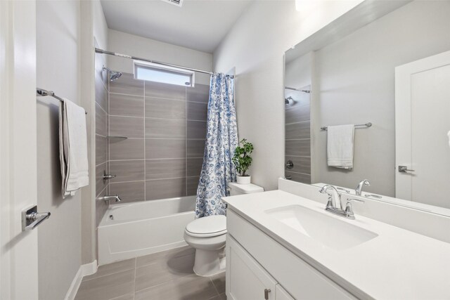 full bath with tile patterned flooring, toilet, vanity, and shower / bath combo