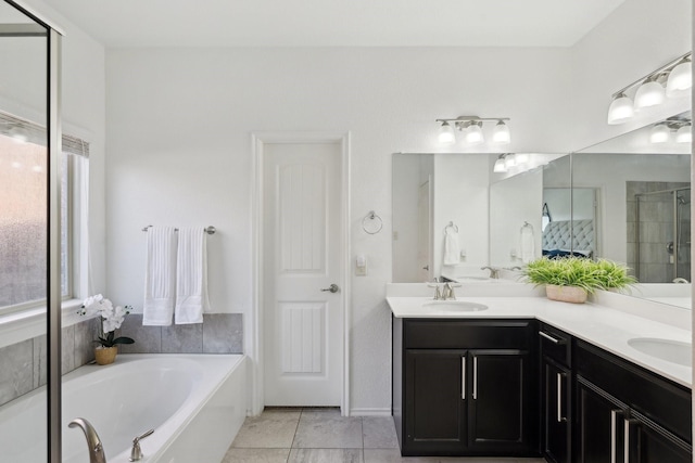 full bathroom with a garden tub, double vanity, a stall shower, tile patterned floors, and a sink