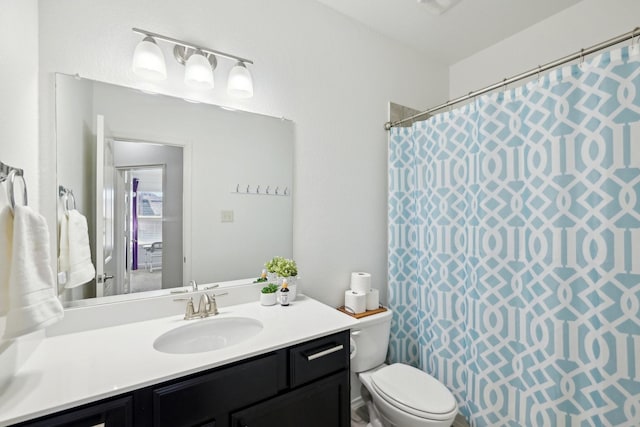 bathroom featuring a shower with shower curtain, toilet, and vanity