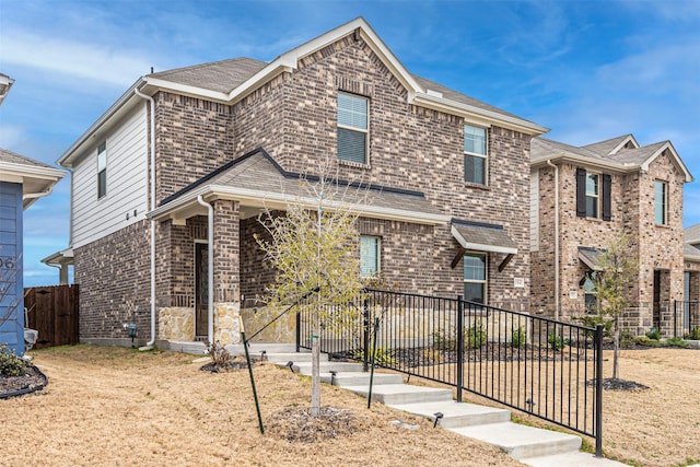 view of front of house with fence and brick siding