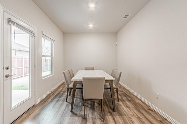 dining space with visible vents, baseboards, and wood finished floors