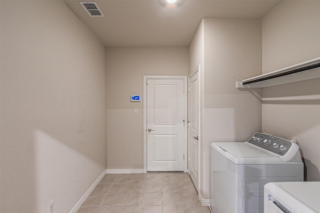 laundry area with light tile patterned floors, baseboards, visible vents, washing machine and clothes dryer, and laundry area