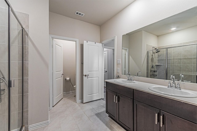 full bathroom featuring double vanity, a stall shower, and a sink