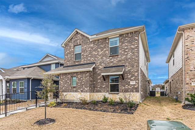 view of front of house featuring brick siding, central AC unit, and fence