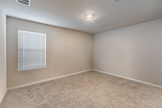 carpeted spare room with baseboards and visible vents