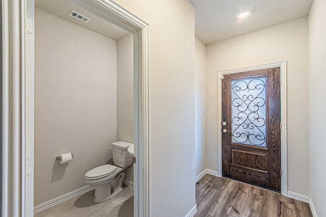 interior space with visible vents, baseboards, toilet, and wood finished floors