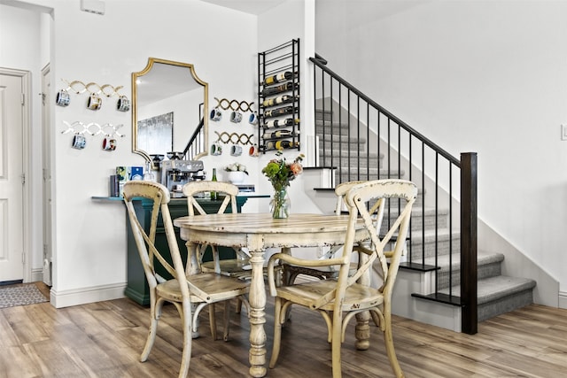 dining area featuring stairway, baseboards, and wood finished floors