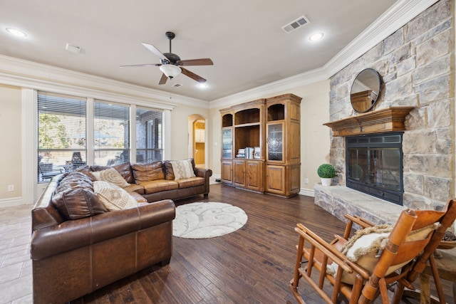 living area featuring visible vents, arched walkways, a fireplace, and crown molding