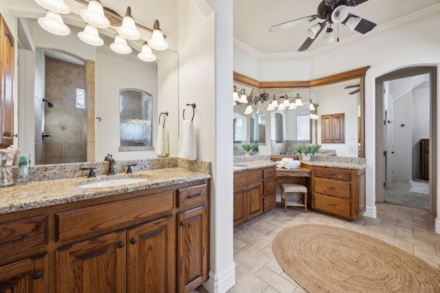 bathroom featuring vanity, tiled shower, crown molding, and ceiling fan