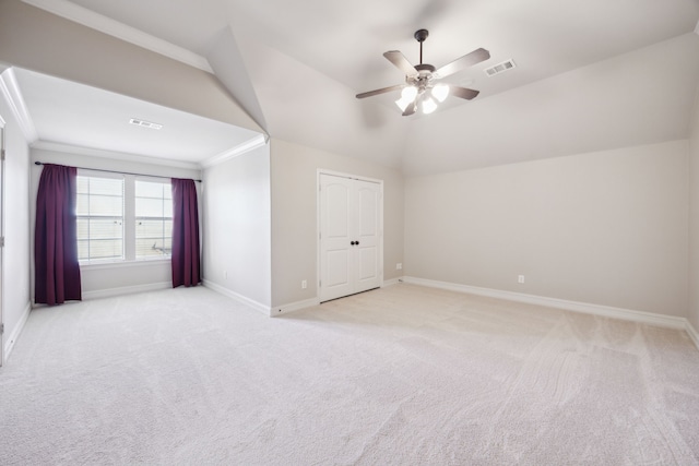 interior space featuring visible vents, ceiling fan, baseboards, vaulted ceiling, and light carpet