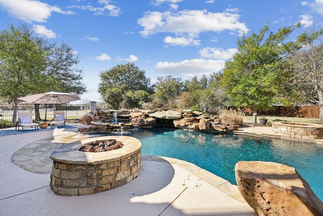 view of swimming pool featuring an outdoor fire pit, a patio, and fence