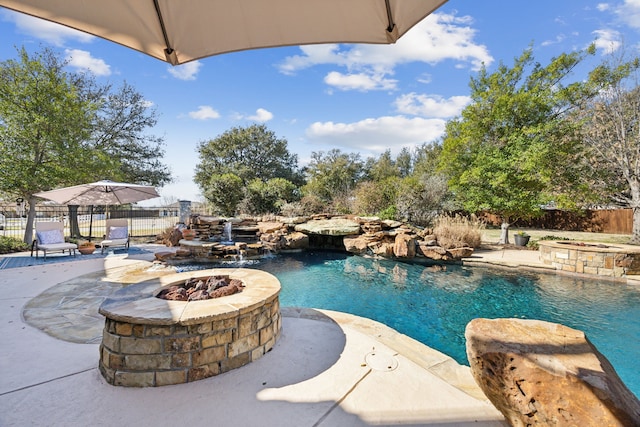 view of pool featuring a patio, fence, and an outdoor fire pit