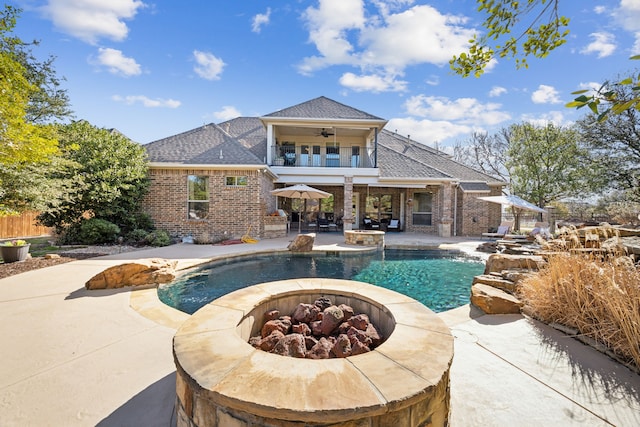 pool with a patio, an outdoor fire pit, a ceiling fan, and fence