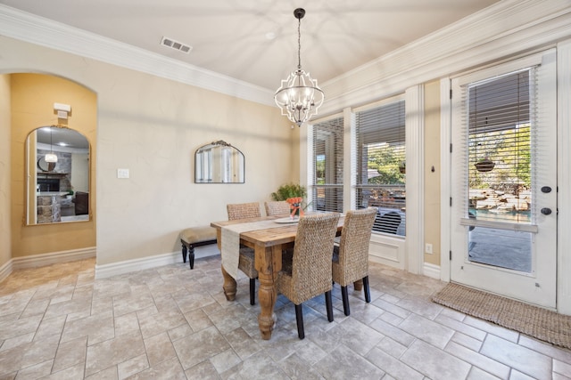 dining room featuring visible vents, crown molding, stone finish flooring, baseboards, and a notable chandelier