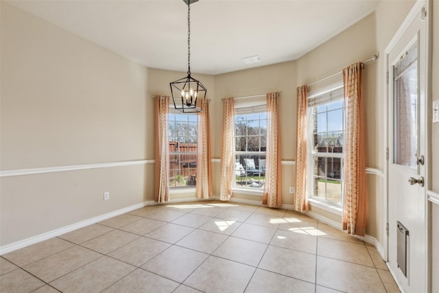 unfurnished dining area featuring light tile patterned floors, a chandelier, visible vents, and baseboards