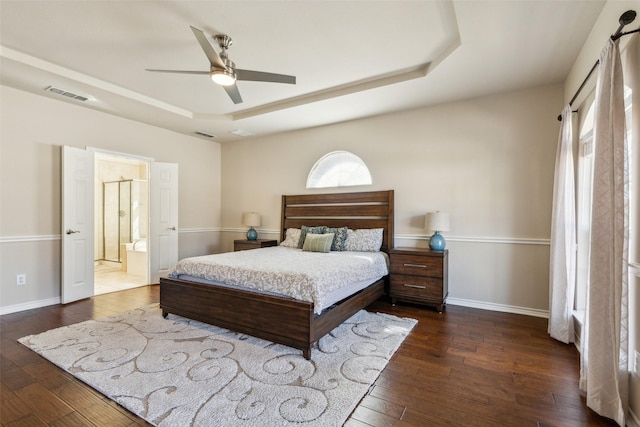 bedroom featuring visible vents, a raised ceiling, baseboards, and wood-type flooring