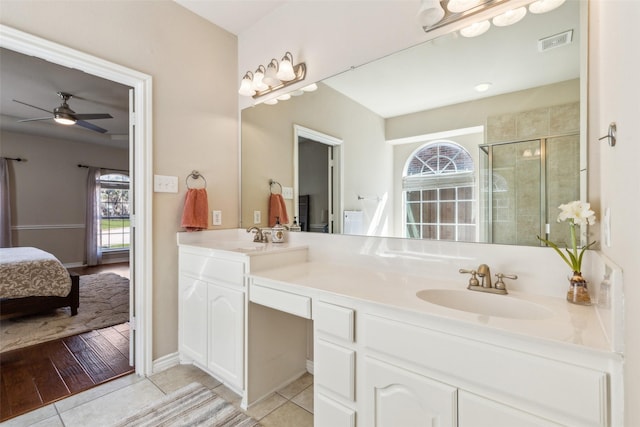 ensuite bathroom with tile patterned flooring, visible vents, a shower stall, double vanity, and a sink