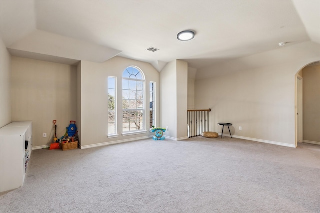 interior space featuring arched walkways, visible vents, carpet flooring, and baseboards