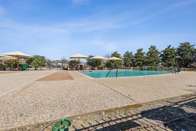 community pool featuring a patio and fence