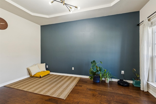 sitting room featuring a notable chandelier, baseboards, and wood finished floors