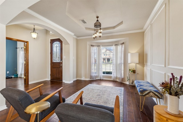 interior space with visible vents, baseboards, dark wood finished floors, arched walkways, and a raised ceiling