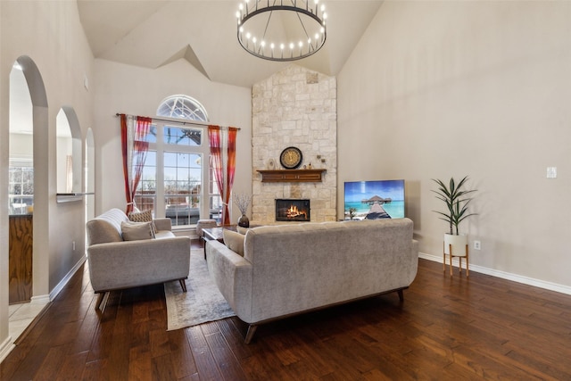 living area featuring hardwood / wood-style floors, a fireplace, baseboards, and high vaulted ceiling