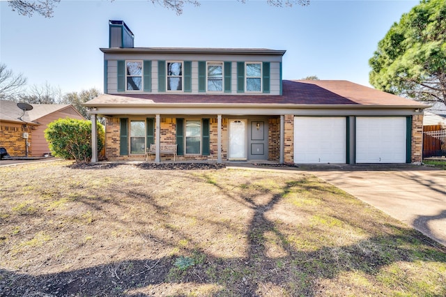 view of front of home with driveway, a porch, a chimney, a garage, and brick siding