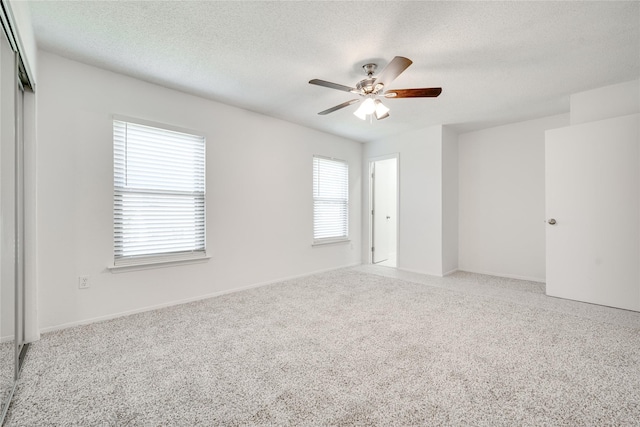 spare room with light carpet, a textured ceiling, and ceiling fan