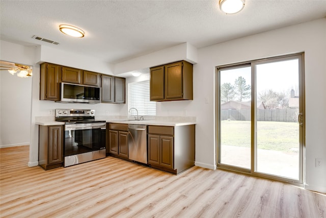 kitchen featuring a sink, visible vents, appliances with stainless steel finishes, and light countertops