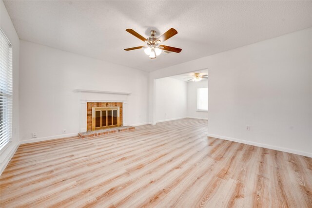 unfurnished living room featuring light wood-style flooring, baseboards, stairs, and ceiling fan