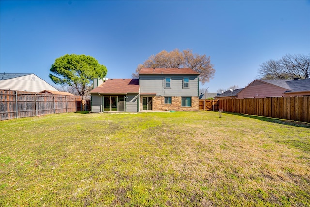 back of property with a lawn and a fenced backyard