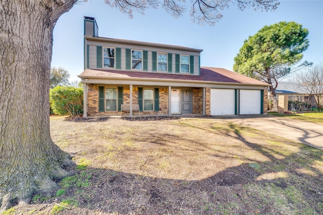 view of front facade featuring brick siding, concrete driveway, a front yard, a chimney, and an attached garage