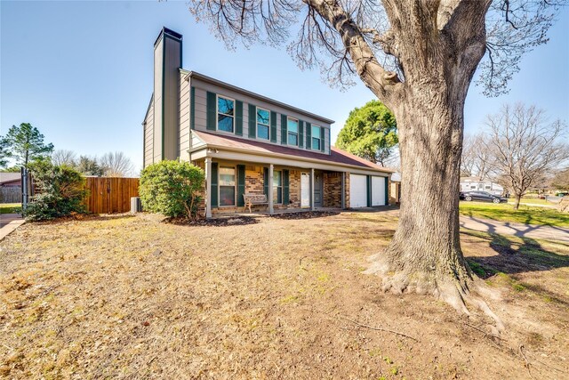 view of front facade featuring brick siding, a front lawn, concrete driveway, a chimney, and an attached garage