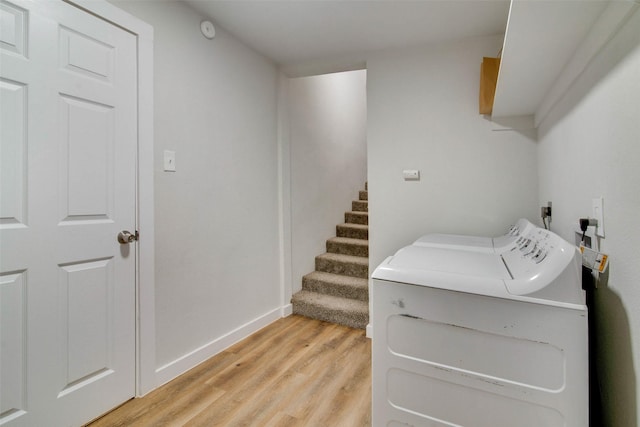 laundry room featuring baseboards, light wood-style flooring, laundry area, and washing machine and clothes dryer