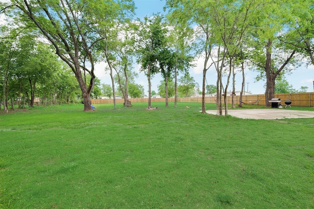 view of community with a patio, fence, and a lawn