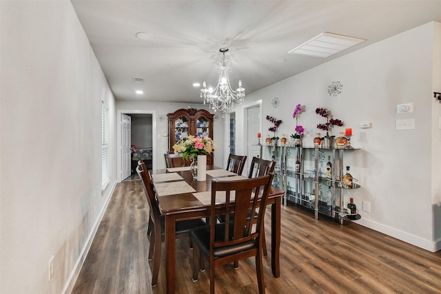 dining space featuring a chandelier, visible vents, baseboards, and wood finished floors