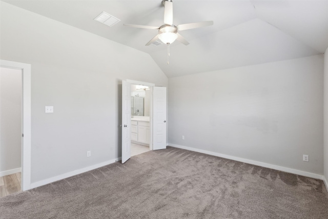 unfurnished bedroom with light carpet, visible vents, baseboards, and lofted ceiling