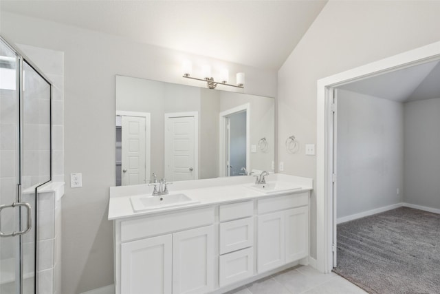 bathroom with double vanity, a stall shower, lofted ceiling, and a sink