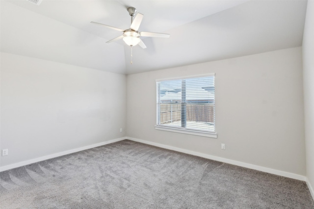 carpeted empty room with baseboards, lofted ceiling, and a ceiling fan