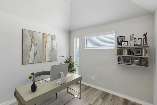 office with baseboards, wood finished floors, and vaulted ceiling