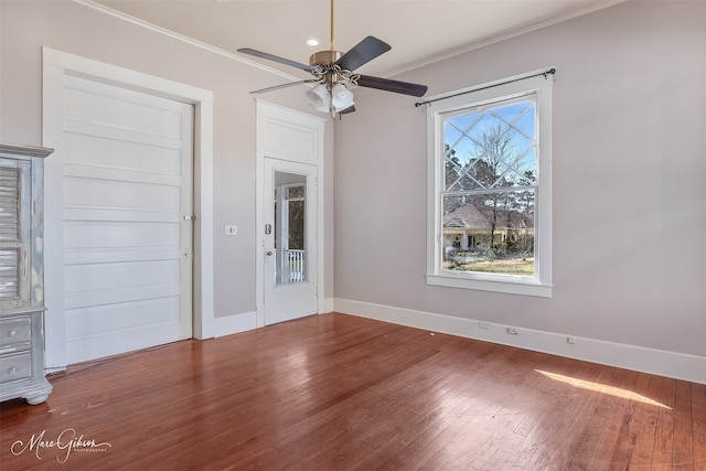 empty room featuring baseboards, wood finished floors, a ceiling fan, and ornamental molding