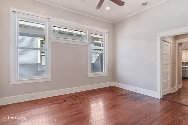 spare room featuring visible vents, ceiling fan, baseboards, hardwood / wood-style floors, and ornamental molding