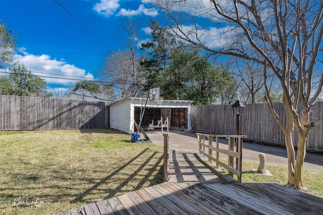 exterior space with a detached garage, an outdoor structure, a fenced backyard, and a lawn