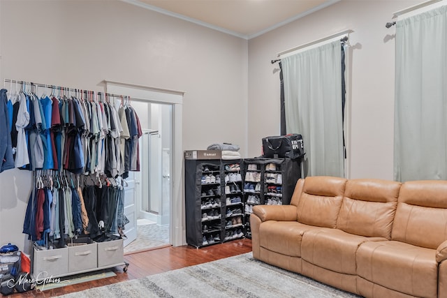 living area with wood finished floors and ornamental molding