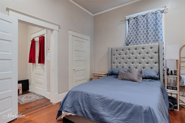 bedroom featuring crown molding and wood finished floors