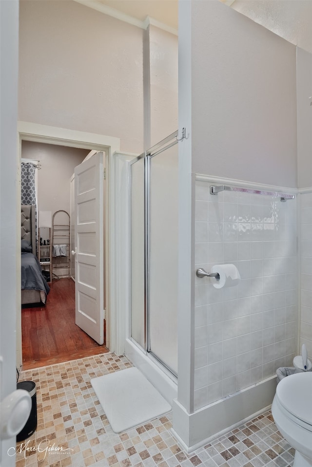 bathroom with tile patterned flooring, toilet, and a stall shower