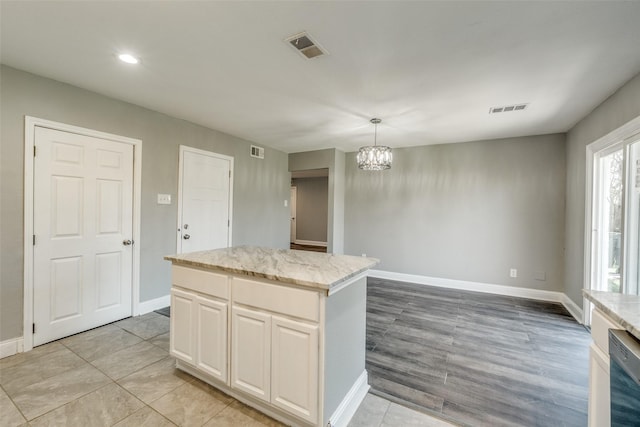 kitchen featuring visible vents, baseboards, dishwashing machine, and a chandelier