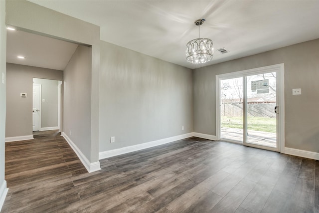 spare room with visible vents, baseboards, a notable chandelier, and dark wood-style flooring