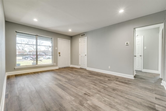 empty room featuring recessed lighting, wood finished floors, and baseboards