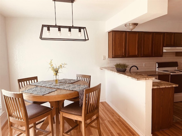 dining area with baseboards and light wood finished floors